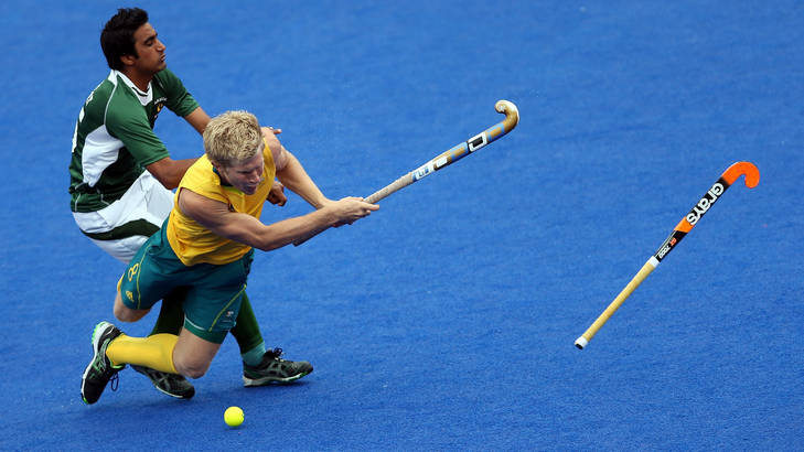 Matthew Butturini of Australia is fouled by Shafqat Easool of Pakistan during their men's hockey preliminary match at the London Olympics.